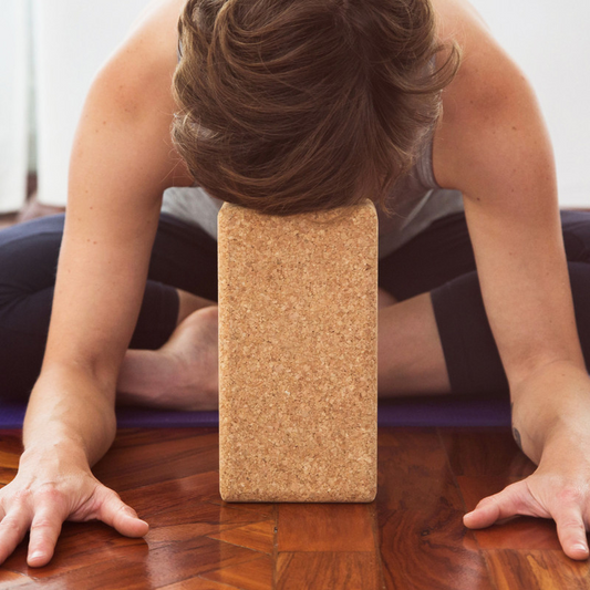Woman in forward bend using yoga block